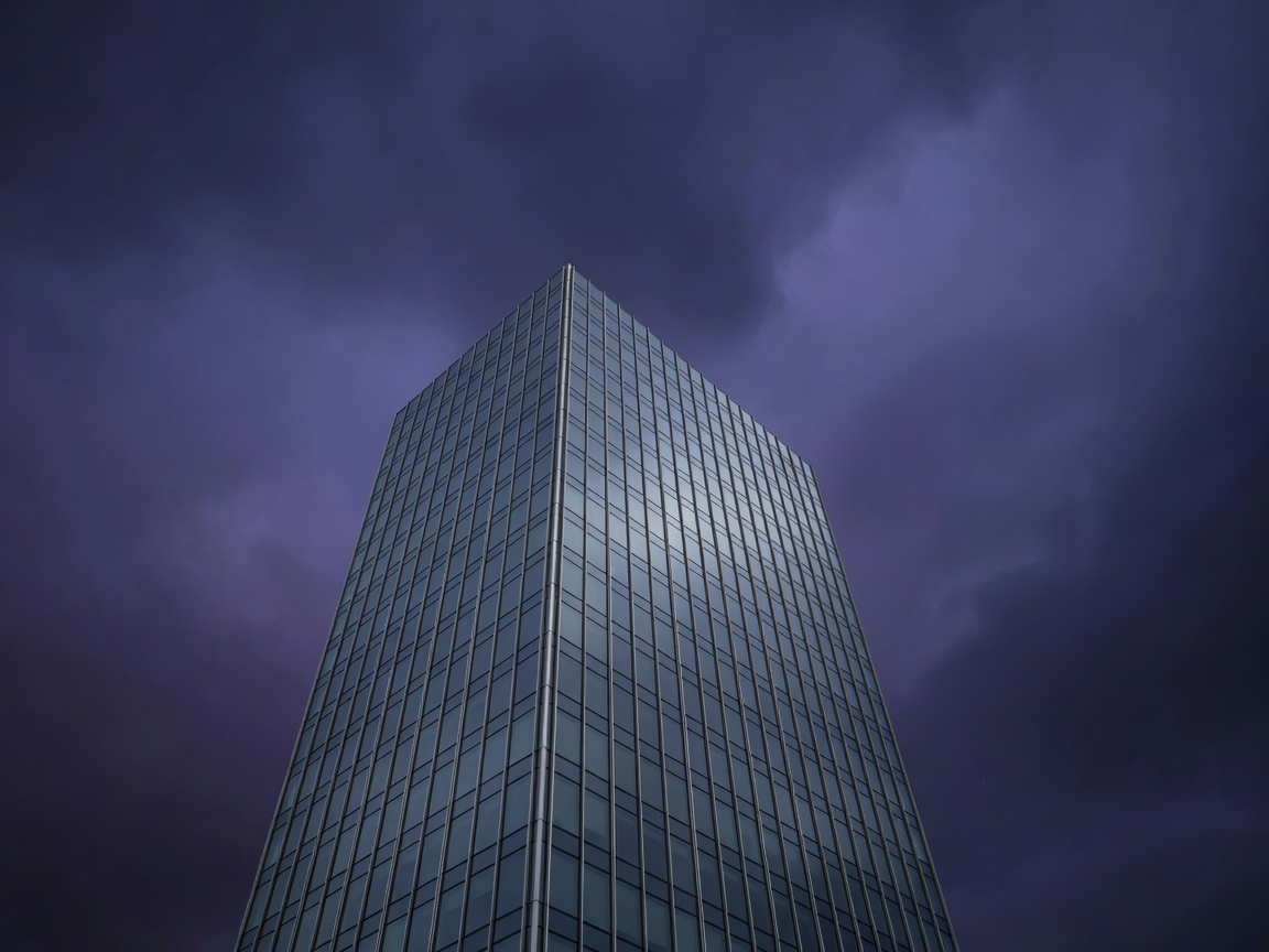 Executive glass skyscraper against dark purple sky